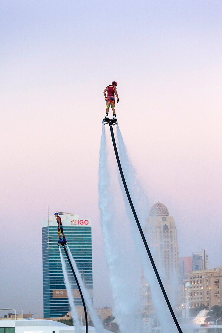 UAE, Dubai, Dubai Marina, Jumeirah Beach, water jet pack stunt flyers, dusk.