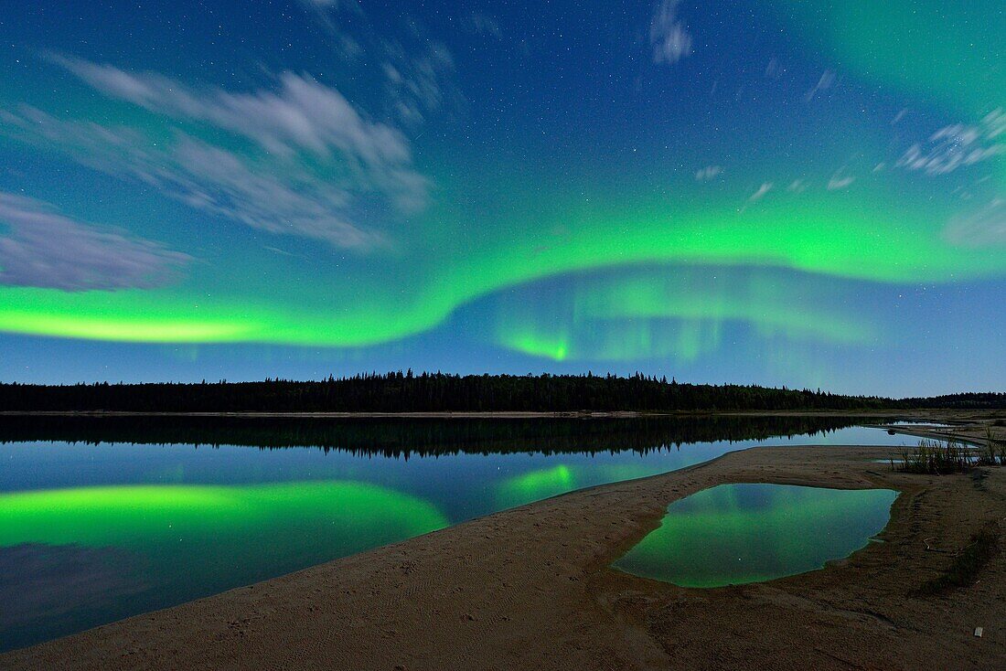 Aurora borelais (Northern Lights) over Pine Lake in moonlight, Wood Buffalo Ntional Park, Alberta, Canada.