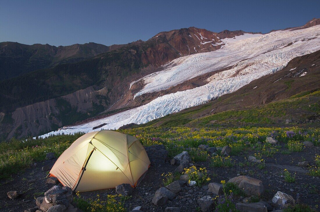 Tent illuminated at dusk on climbers camp on slopes of Heliotrope Ridge, Mount Baker Wilderness North cascades Washington.