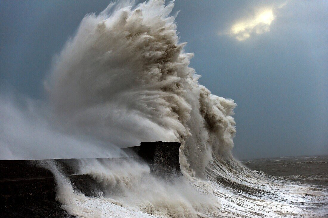 Huge waves crash against the harbour wall at Porthcawl, Bridgend, Wales, UK.