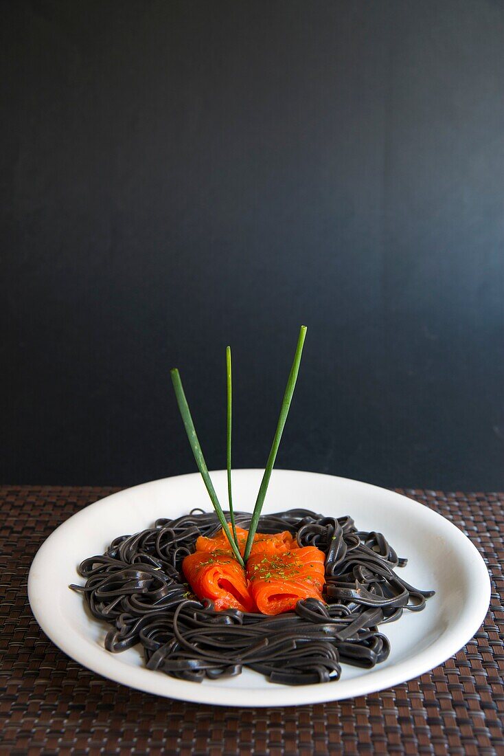 Black spaghetti with smoked salmon and chives.