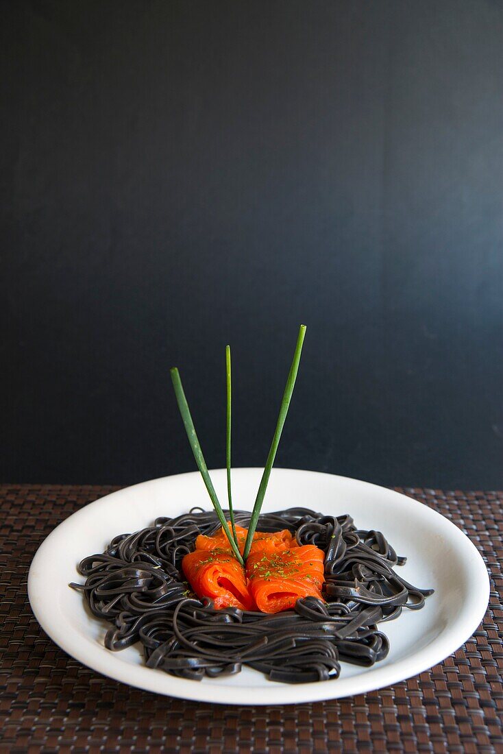 Schwarze Spaghetti mit Räucherlachs und Schnittlauch.