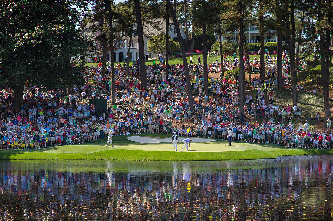 Zuschauer füllen den Hügel hinter dem 9. Grün des Par 3 Kurses, während Spieler ihre Runde im Augusta National Golf Club, Augusta, Georgia, Vereinigte Staaten von Amerika, Nordamerika beenden