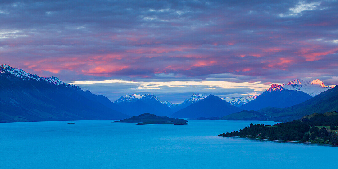Mount Earnslaw and neighbouring mountain peaks in the Southern Alps are lit with the last rays of the sun beyond Lake Wakatipu, Otago, South Island, New Zealand, Pacific