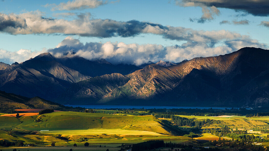 The plains and lakes of Otago region framed by cloud capped mountains, Otago, South Island, New Zealand, Pacific