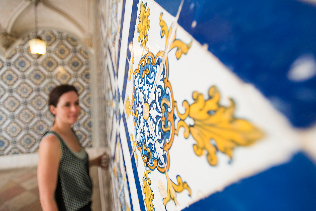 Eine Frau bewundert Beautuful Azelejo Fliesen auf dem Display im National Azulejo Museum in Lissabon, Portugal, Europa