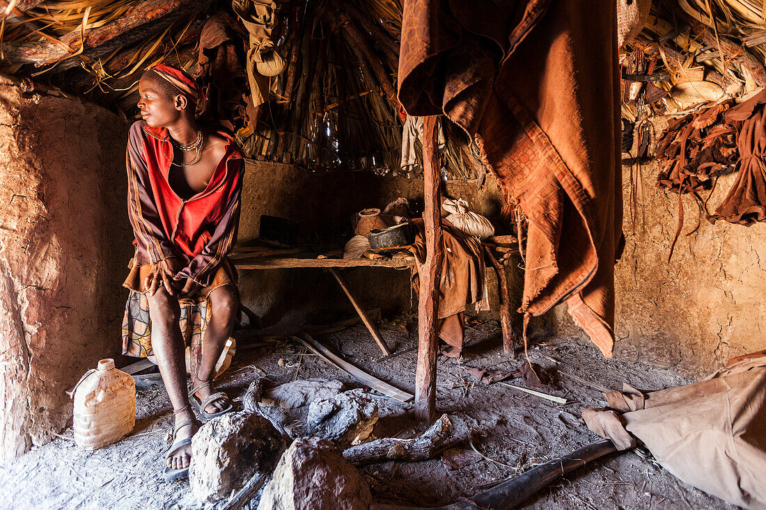 Young Himba man in his hut, Kunene, Namibia, Africa
