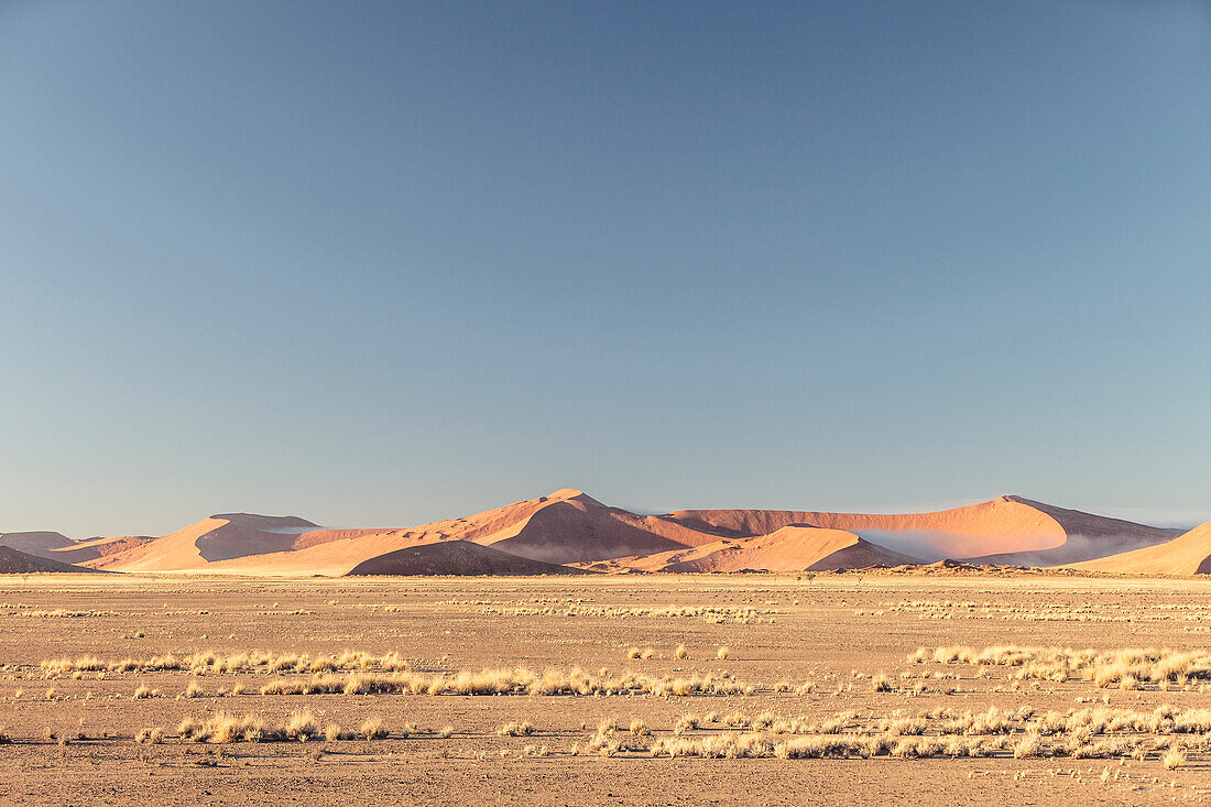 Morning fog between the dunes of Sossusvlei after a cold night, Namib Naukluft National Park, Hardap, Namibia, Africa.