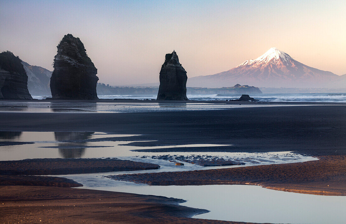 Rock formations and view of Mount Taranaki volcano, Tongaporutu, Taranaki, North Island, New Zealand, Oceania