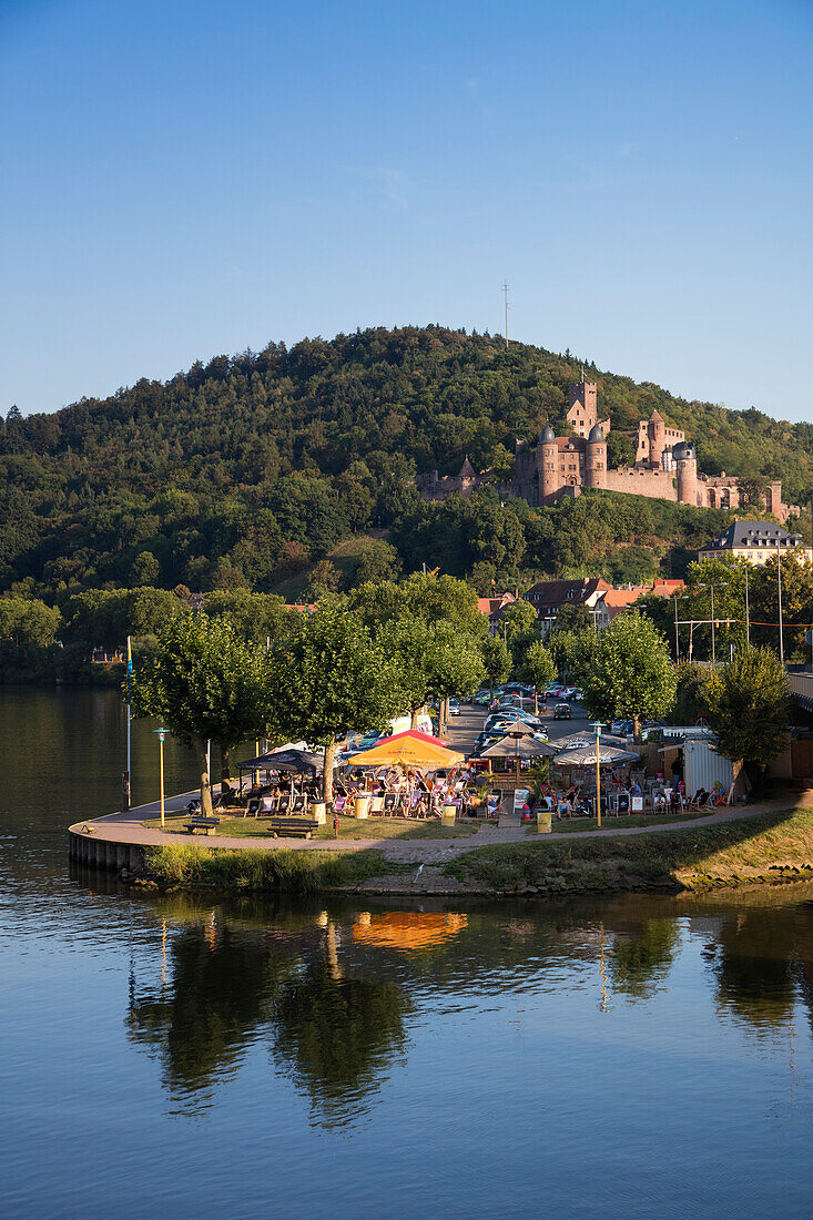 Gäste genießen einen lauen Sommerabend im Wertheimer Beach Club am Ufer vom Fluss Main mit Burg Wertheim dahinter, Wertheim, Spessart-Mainland, Franken, Baden-Württemberg, Deutschland