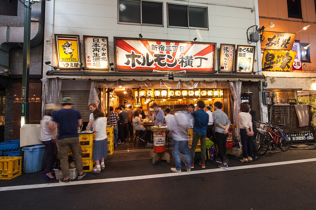 Japanische Kneipe am Abend mit jungen Leuten die zusammen essen und trinken, Shinjuku, Tokio, Japan