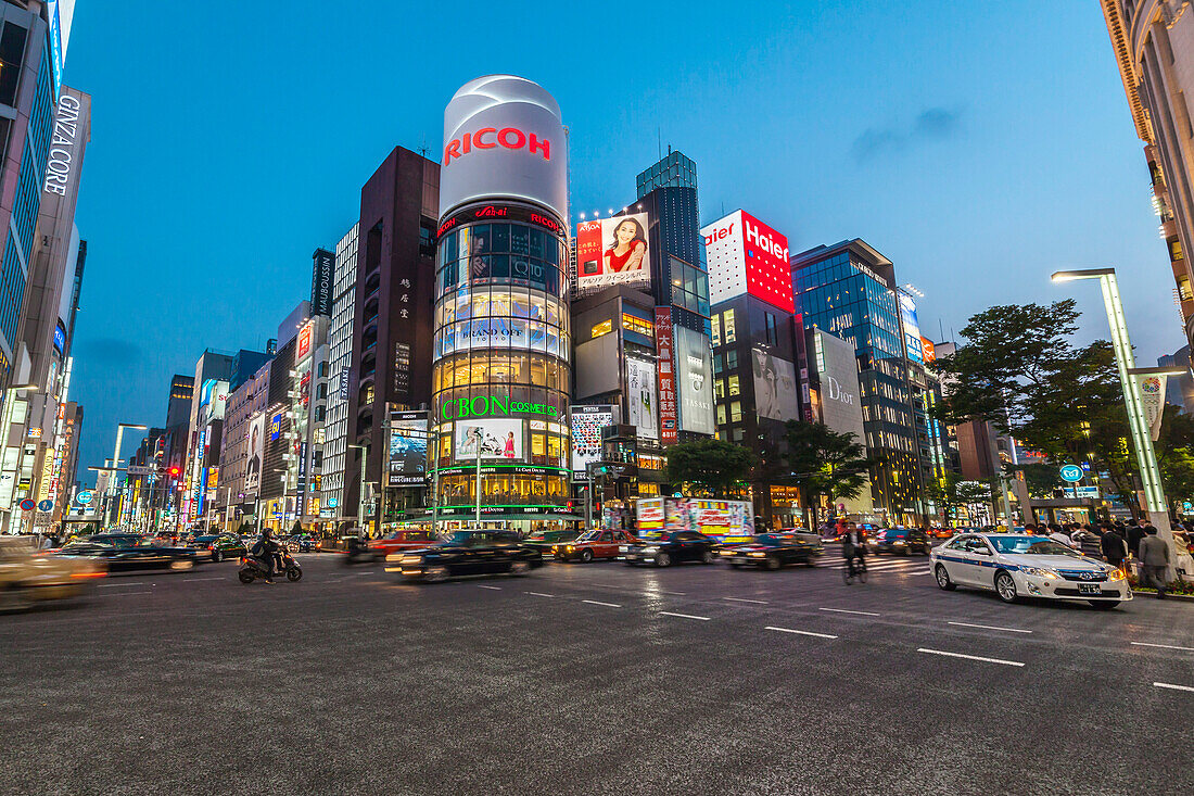 Kreuzung mit Autos am Ricoh Imaging Square in der Ginza während der blauen Stunde, Chuo-ku, Tokio, Japan