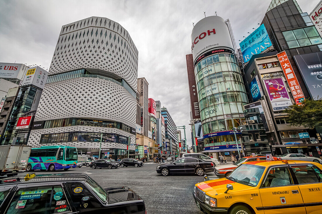 Crossing with cars at Ginza Place and Imaging Square at cloudy day, Chuo-ku, Tokyo, Japan