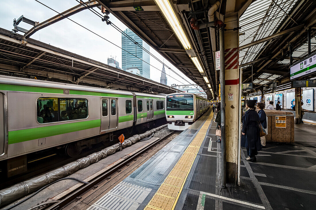Pendler warten am Bahnsteig der Bahnhof Shinjuku auf Zug der Yamanote Line, Shinjuku, Tokio, Japan