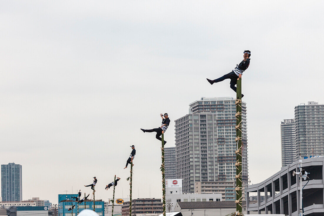 Akrobatische Vorführung traditioneller Feuerlöschtechnik während der Dezome-shiki Parade in Odaiba, Tokio, Japan