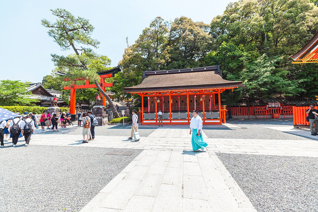 Tourists and monk at Fushimi Inari-Taisha in Kyoto, Japan