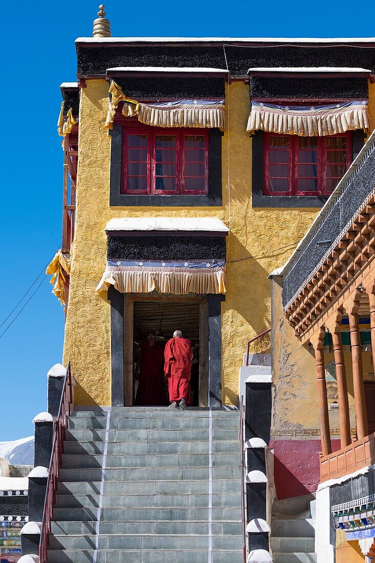 Thiksey Monastery, Indus Valley, Ladakh, India, Asia. Buddhist monk in front of temple entrance.