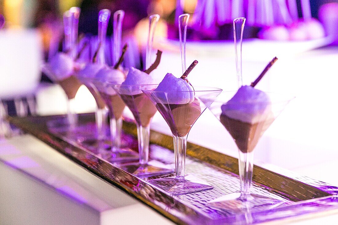 Chocolate mousse served in martini glasses at a party.
