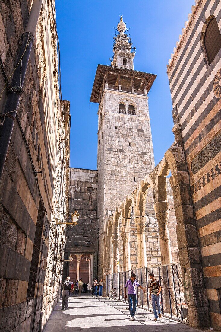 Minaret of the Bride, the oldest of the Umayyad Mosque, seen from an alley. Damascus, Syria.