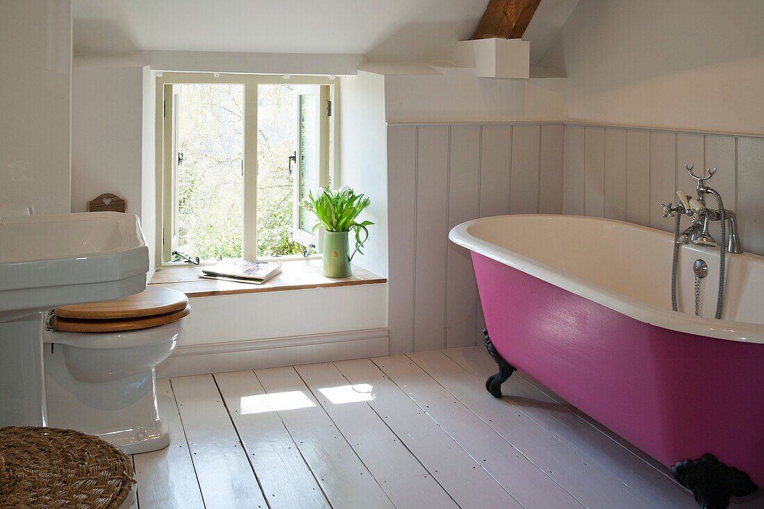 UK homes. A small cottage bathroom with beams, painted floor and a pedestal bath,. For Editorial Use Only.