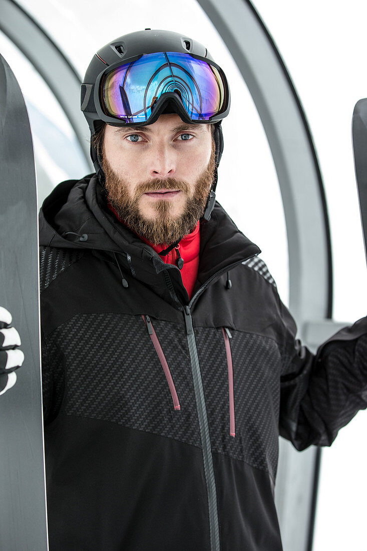 Young male skier standing with his skis in a tunnel for persons, Kaprun, Salzburg, Austria