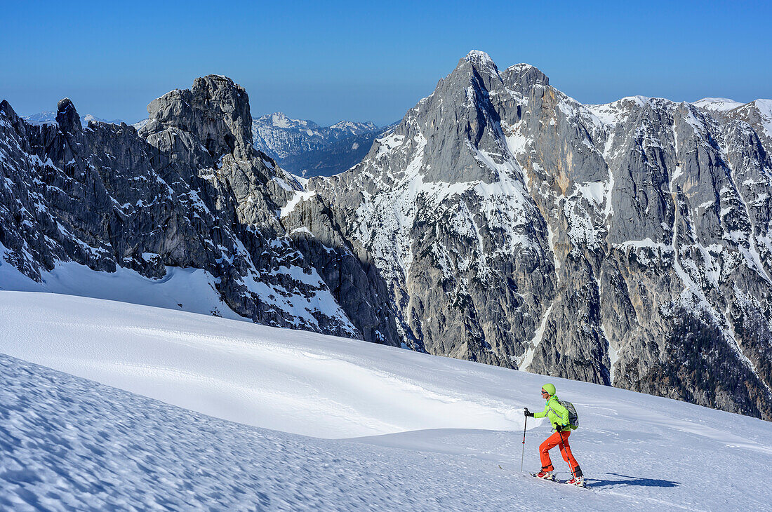 Woman backcountry skiing ascending towards Hochfeldscharte, Reiteralm in background, Sittersbachtal, Hochfeldscharte, National Park Berchtesgaden, Berchtesgaden Alps, Upper Bavaria, Bavaria, Germany