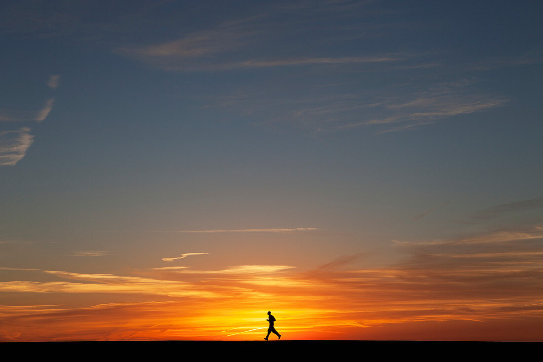 'Man jogging at sunrise; Chicago, Illinois, United States of America'