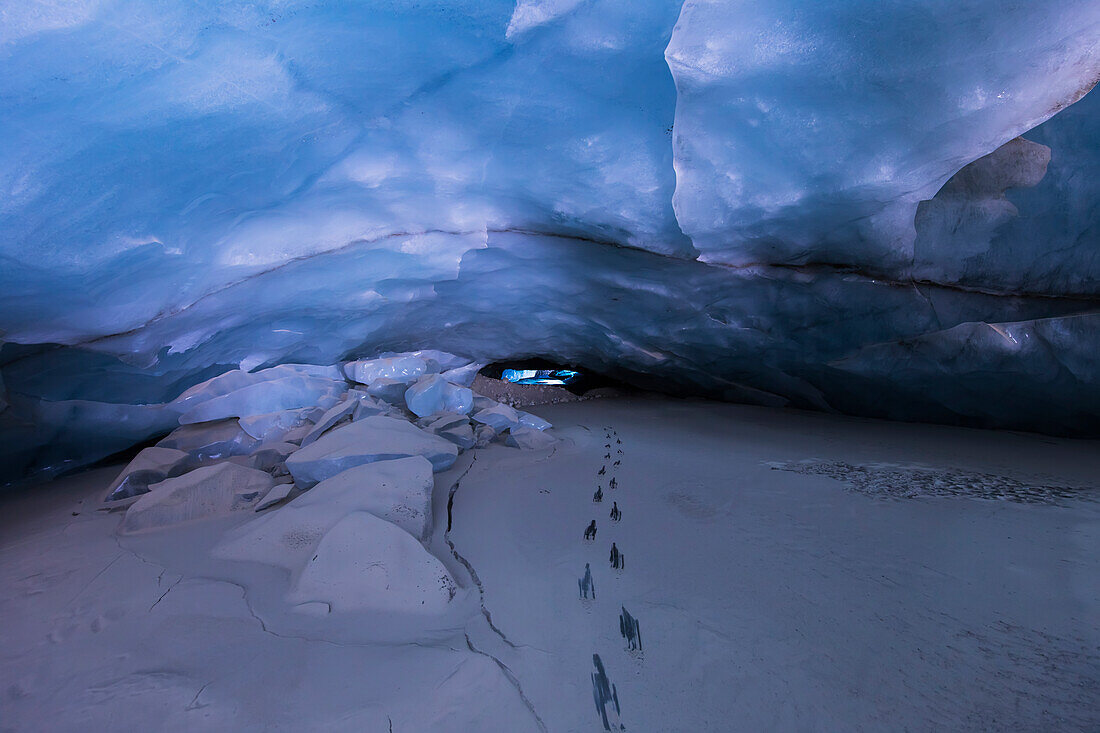 'Footsteps reveal solid ice beneath a thin layer of glacial silt in this tunnel carved into the ice of Black Rapids Glacier by a melt water stream.; Alaska, United States of America'