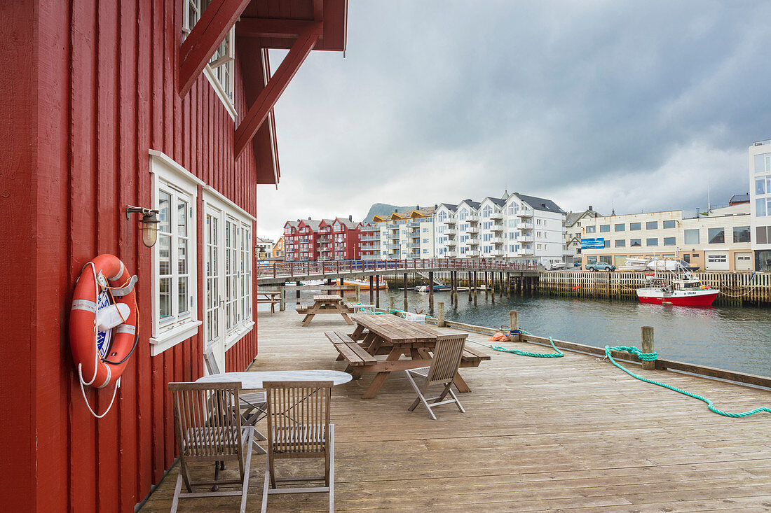 Clouds frame the typical wooden houses of the fishing village surrounded by sea, Svolvaer, Vagan, Lofoten Islands, Norway, Scandinavia, Europe