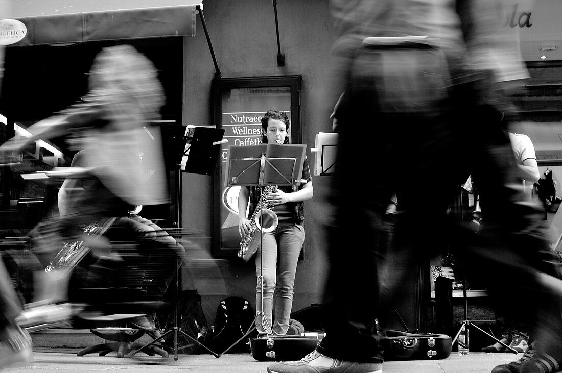 Bologna street photography, Musicians perform on the street in front of public on the move