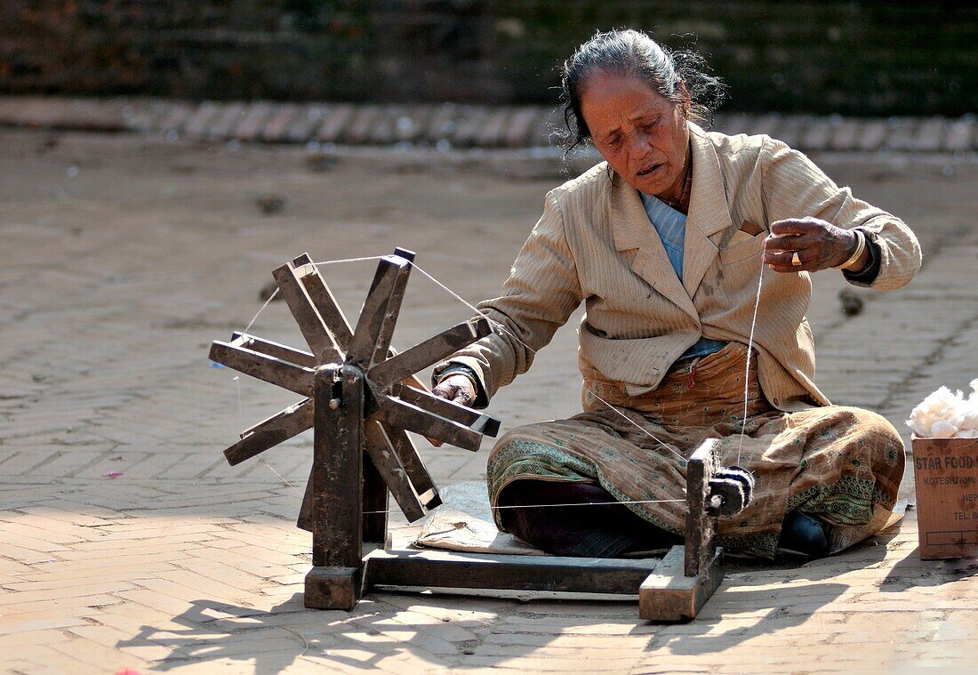 Kathmandu, you will find various craftsmen intent on their work, This woman is a weaver and devoted himself to his wool in a square in Bhaktapur, Nepal