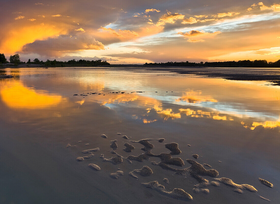 Po river park, Piedmont, Italy, Golden clouds, painted by the sunset, reflected by the river' water po
