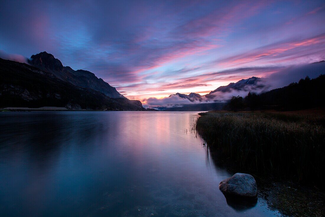 The colours of the dawn reflected in Lake Sils, Maloja Pass, Enagdine Canton of Graubunden Switzerland Europe
