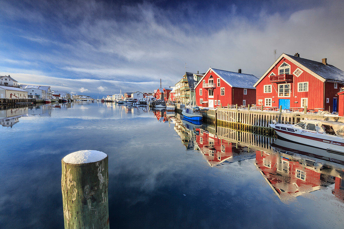 Red houses reflected in the canal of Henningsvaer, Lofoten Islands, Norway, Europe
