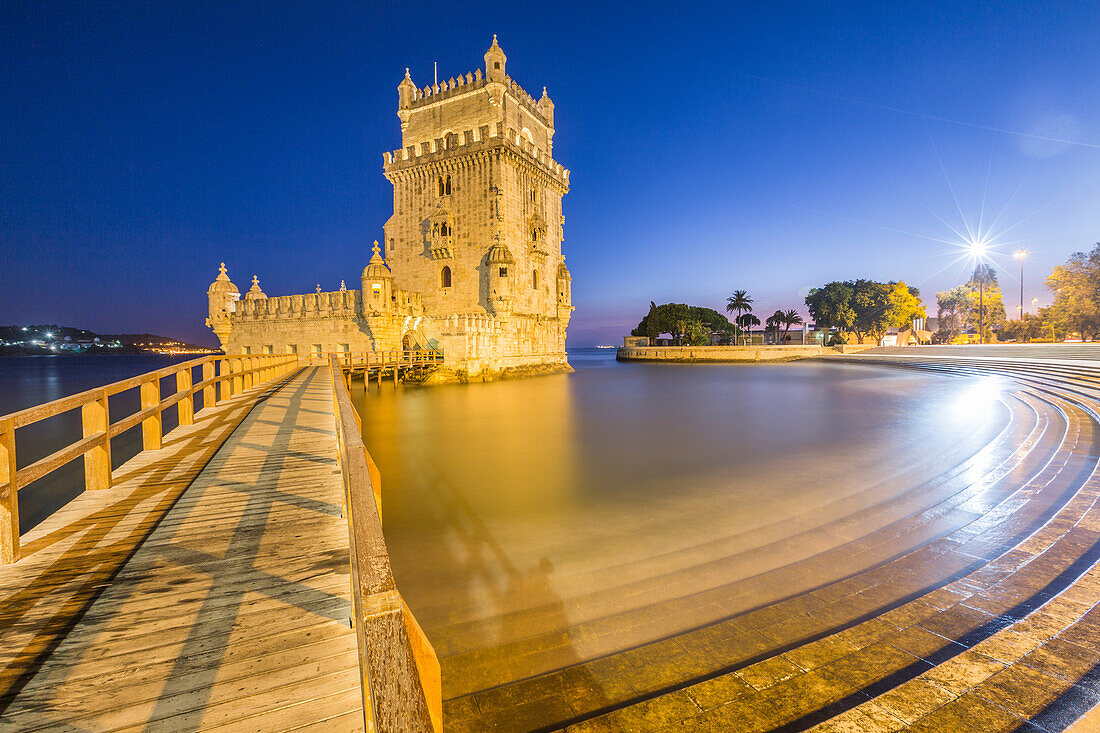 Blue dusk and lights on the Tower of Bel+®m reflected in Tagus River Padr+úo dos Descobrimentos Lisbon Portugal Europe