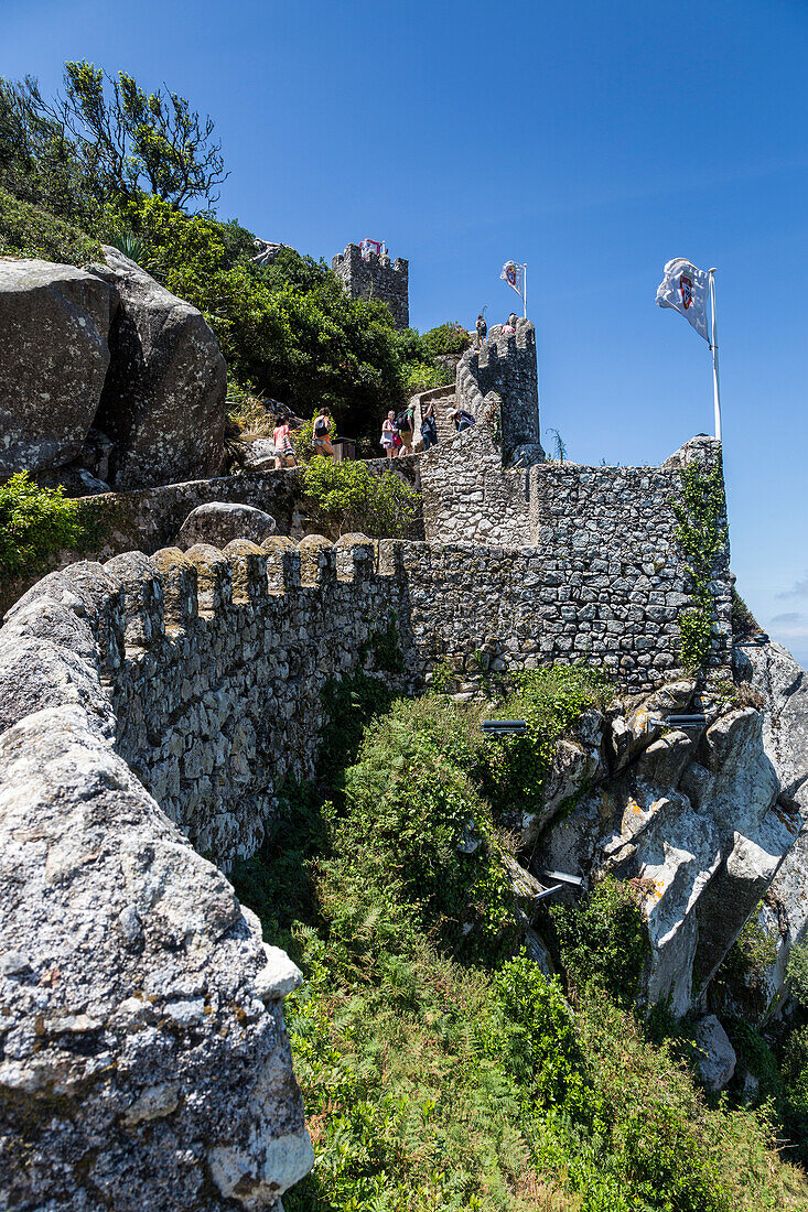 Tourists proceed towards the fortified stone tower of Castelo dos Mouros Sintra municipality Lisbon district Portugal Europe