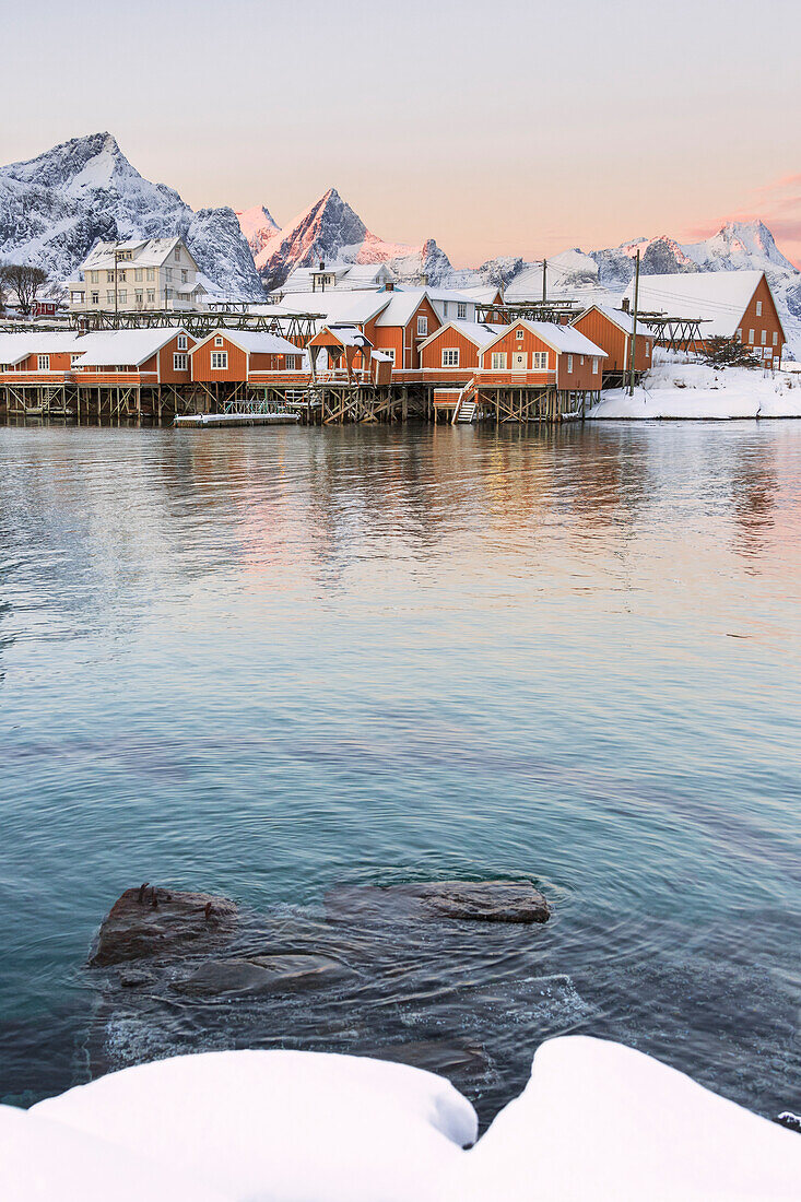 The colors of dawn frames the fishermen houses surrounded by snowy peaks Sakris+©y Reine Nordland Lofoten Islands Norway Europe