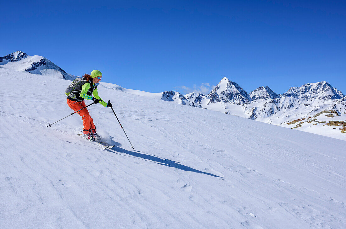 Frau auf Skitour fährt von der Köllkuppe ab, Zufallspitzen, Königsspitze, Zebru und Ortler im Hintergrund, Köllkuppe, Cima Marmotta, Martelltal, Ortlergruppe, Vinschgau, Südtirol, Italien