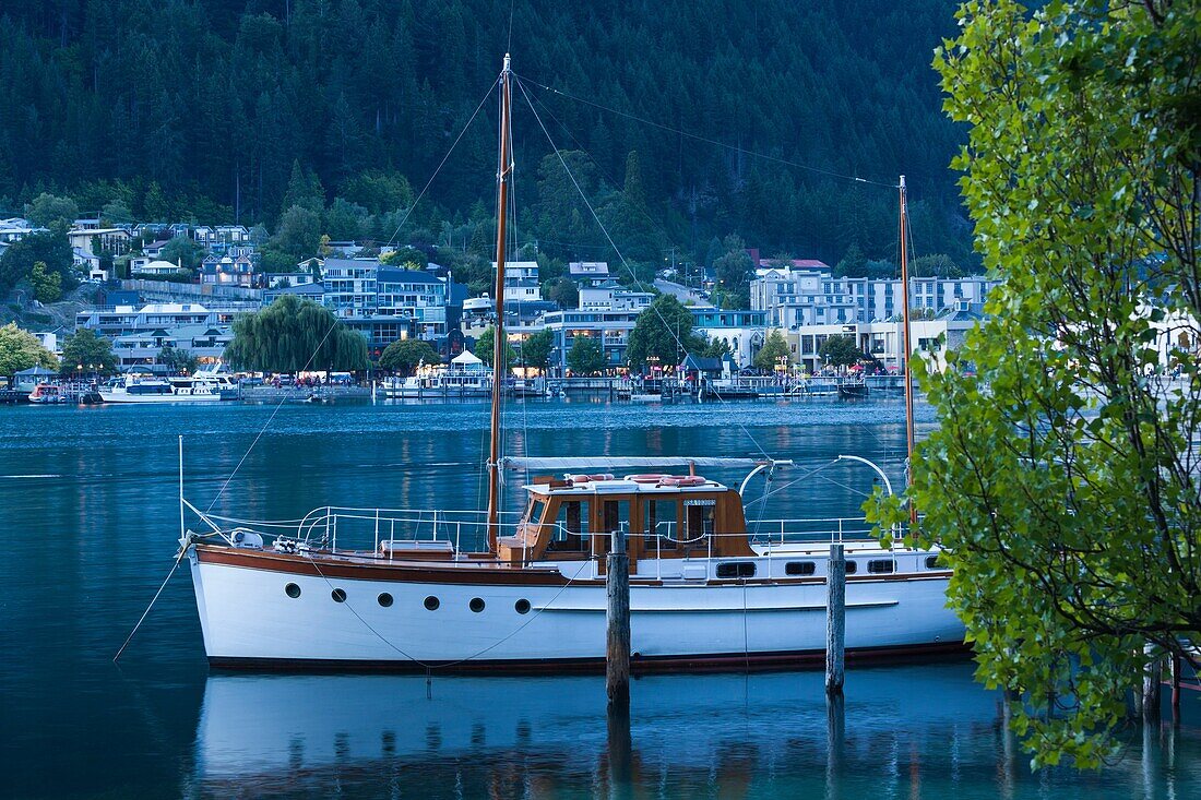 New Zealand, South Island, Otago, Queenstown, harbor view with boat, dusk.