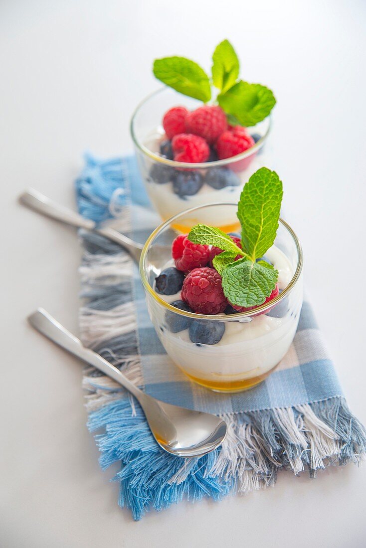 Cream with honey, blueberries, raspberries and mint leaves.