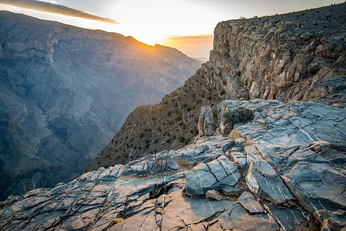 Jebel Shams, Sun shines over the summit and gorge at Oman's Grand Canyon.