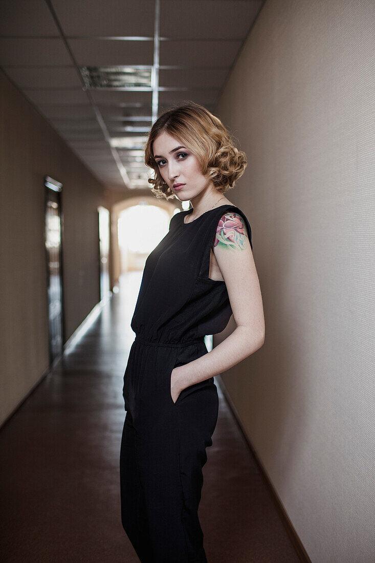 Portrait of beautiful young woman standing in corridor