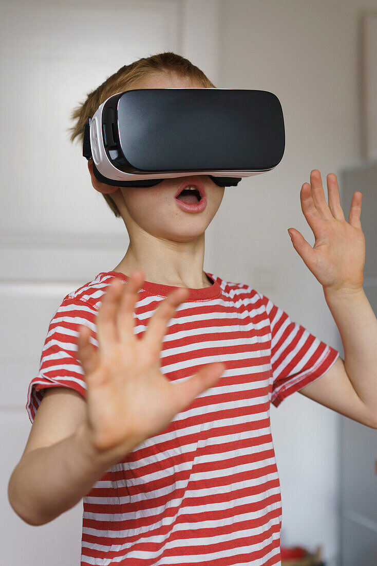 Boy using virtual reality simulator at home
