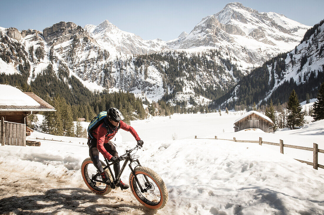 A young man on a fatbike, snowbike, mountainbike  at Lauenensee near Gstaad, Bernese Oberland, Switzerland