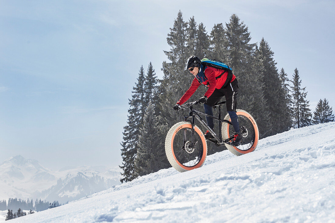 A young man on a fatbike, snowbike, mountainbike at Sparenmoos above Gstaad, Bernese Oberland, Switzerland