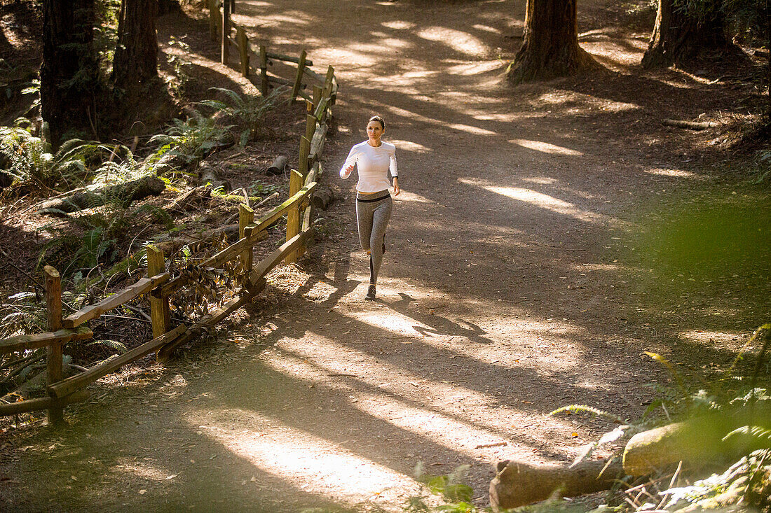 Woman running on forest path