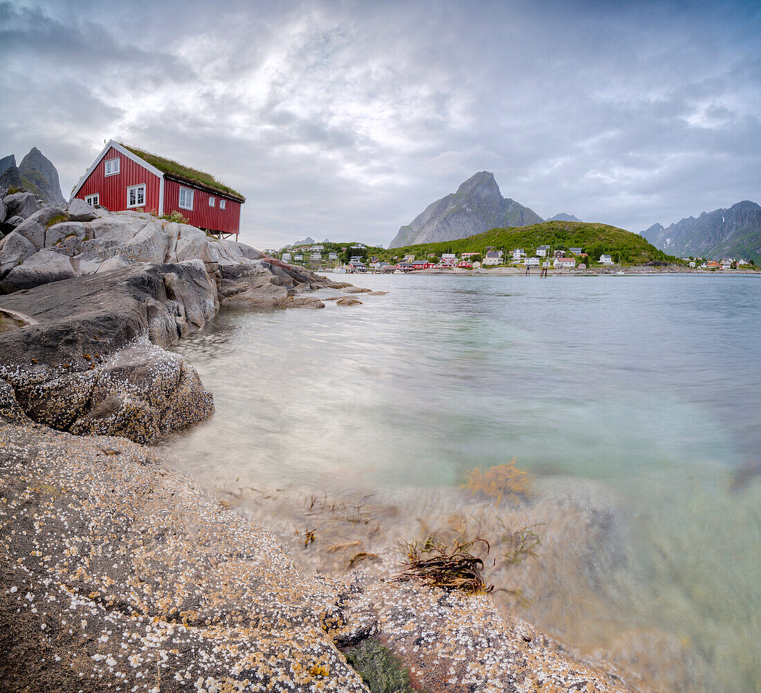 Panoramic of the typical Rorbu surrounded by peaks and clear sea Reine Nordland county Lofoten Islands Northern Norway Europe