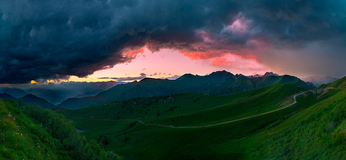 Crocedomini Pass, Adamello Park, Lombardy, Italy The colors of the sunset in the clouds of two storms, Panoramic photo of the valley below the pass Crocedomini