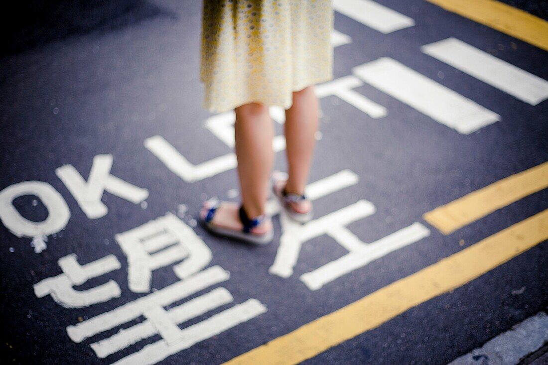 Girl wait in road, Kowloon, Hong Kong, China.