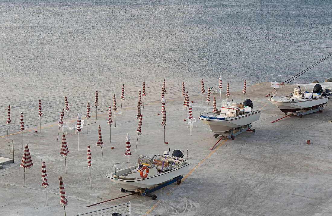 High angle view of boats and closed parasols on beach